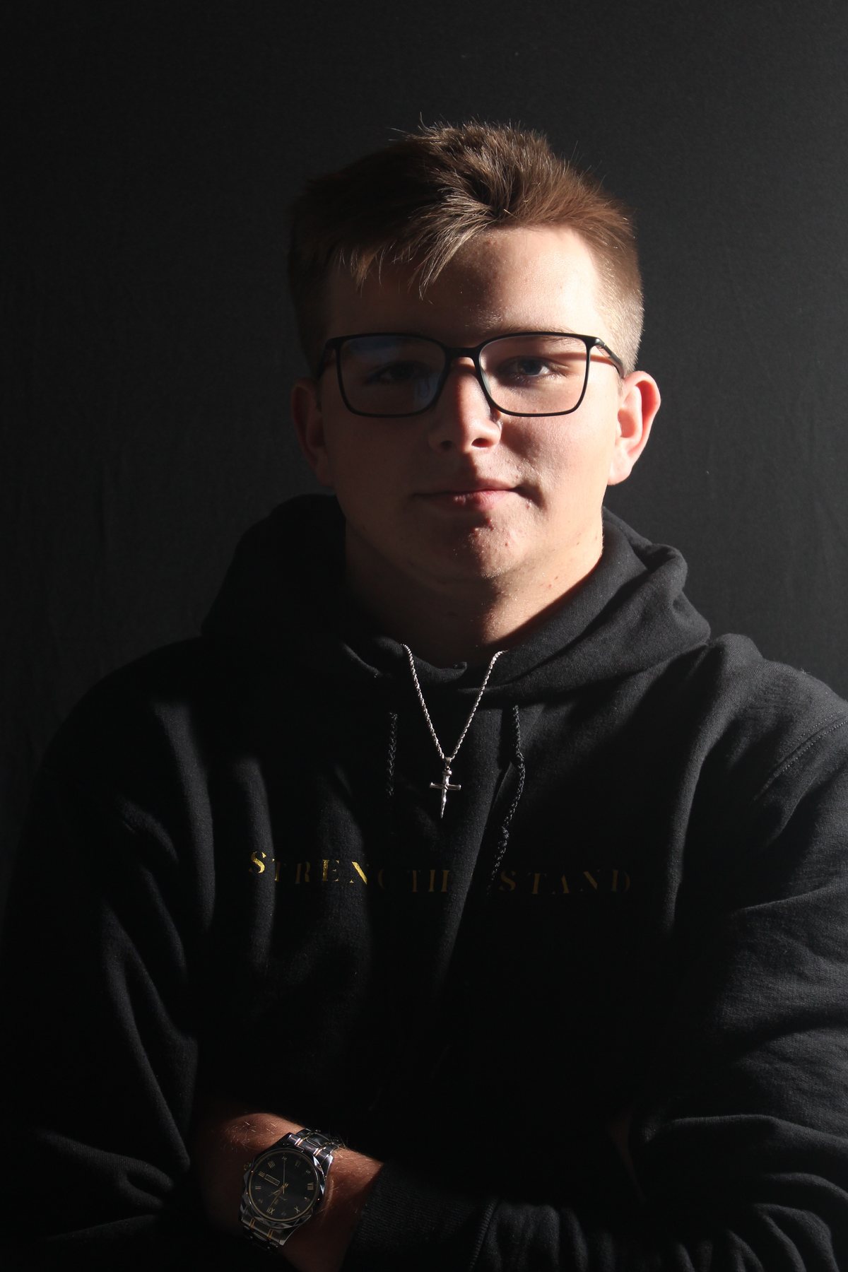 Portrait of the founder of AWILL in a black hoodie against a dark background