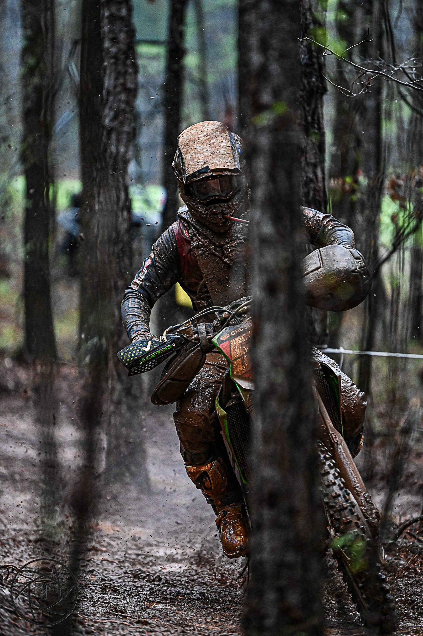 Off road motorcycle racer riding through pine woods during a GNCC round