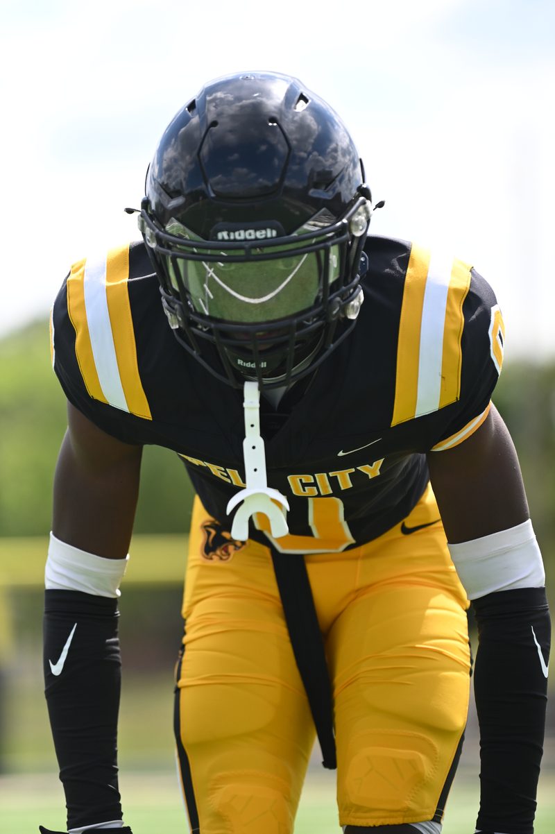 Close up of a black and gold high school football helmet during warmups
