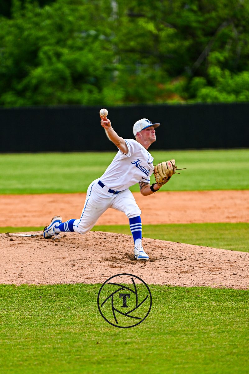 Baseball pitcher in a blue and white uniform mid delivery from the mound