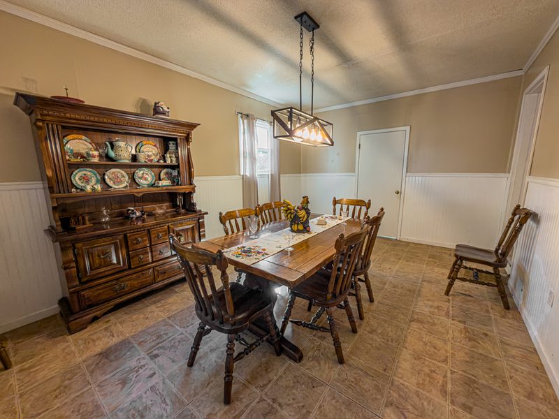 Dining room with a wood table, china hutch and a hanging light fixture