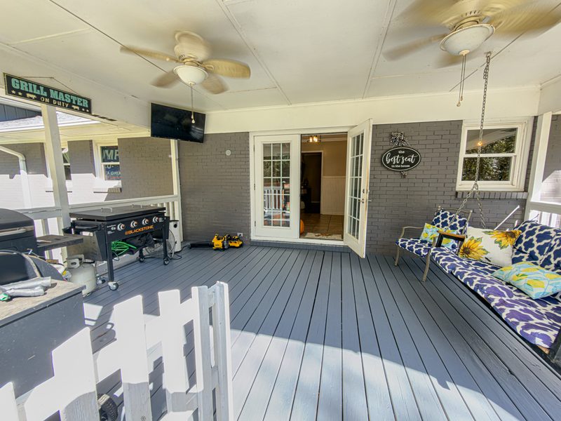 Covered back deck with a porch swing, a grill and french doors into the house
